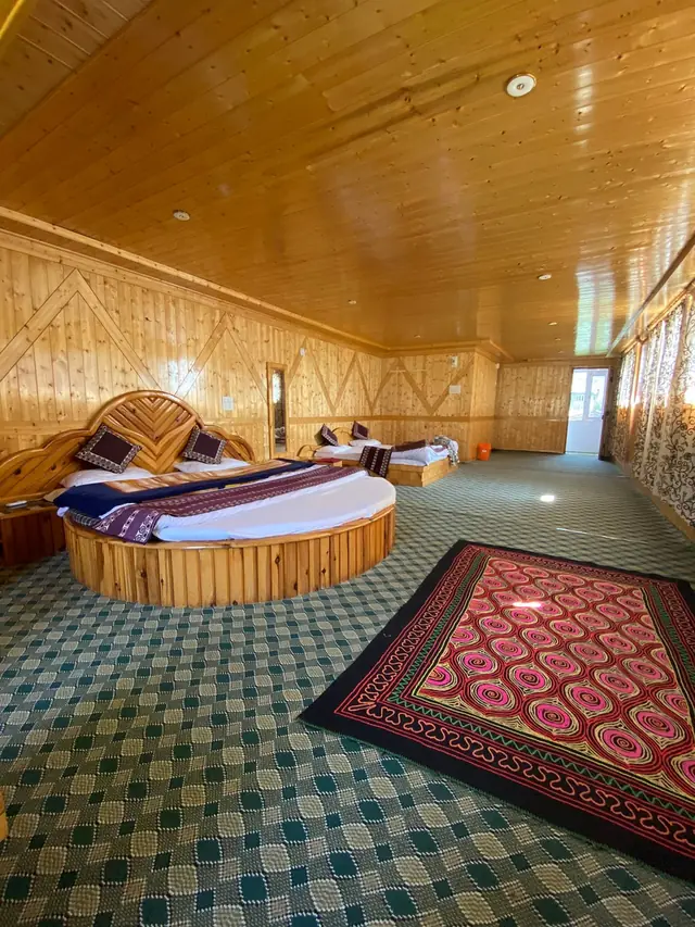 Spacious family suite with round bed and traditional rugs at Tulip Cottage Pahalgam